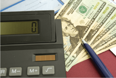 Five Twenty Dollars Bills with Calculator Resting on Top